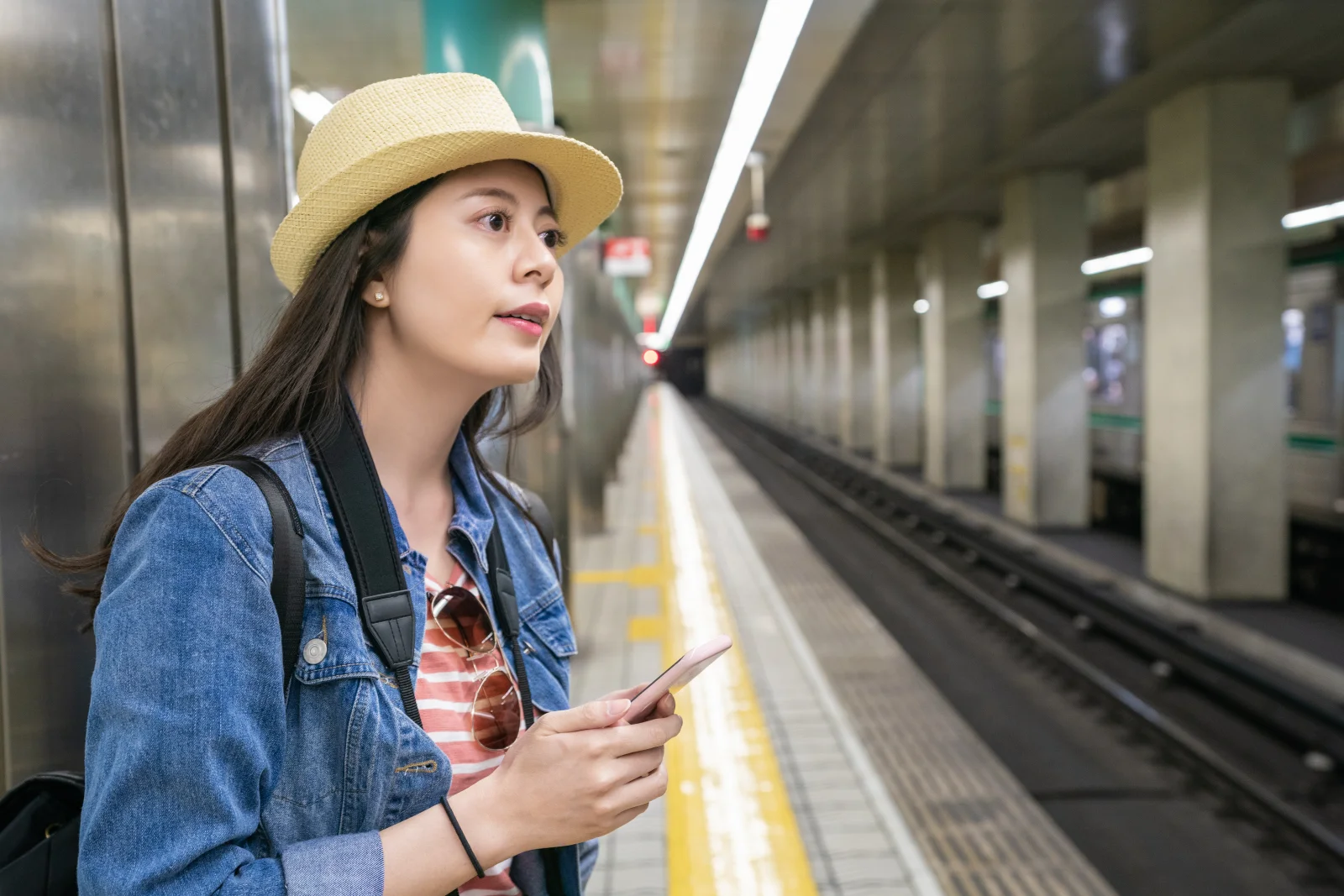Japonya'da bir metro peronunda akıllı telefonunu kullanan yolcu