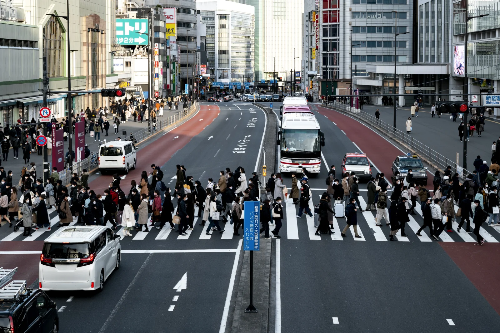 Tokyo Shinjuku'da kalabalık bir yaya geçidinden karşıya geçen insanlar